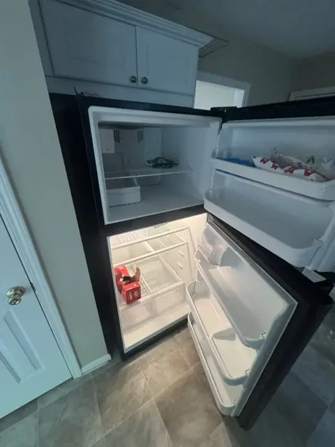 The same refrigerator after cleaning: empty, wiped down, drawers back in place